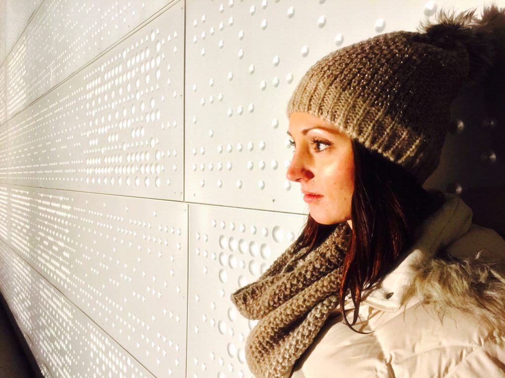 Woman's profile standing against the textured wall of the Oslo Opera House