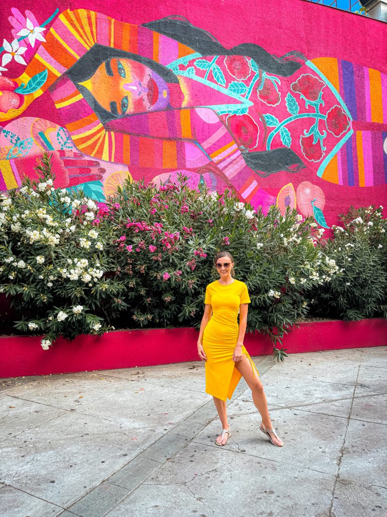 Woman standing in front of colorful mural in Providencia 