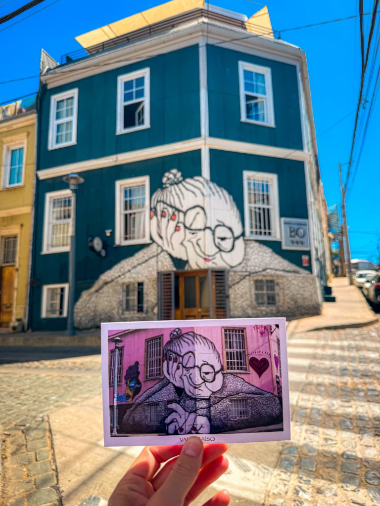 Valparaiso Chile postcard of street art held up in front of the same street mural