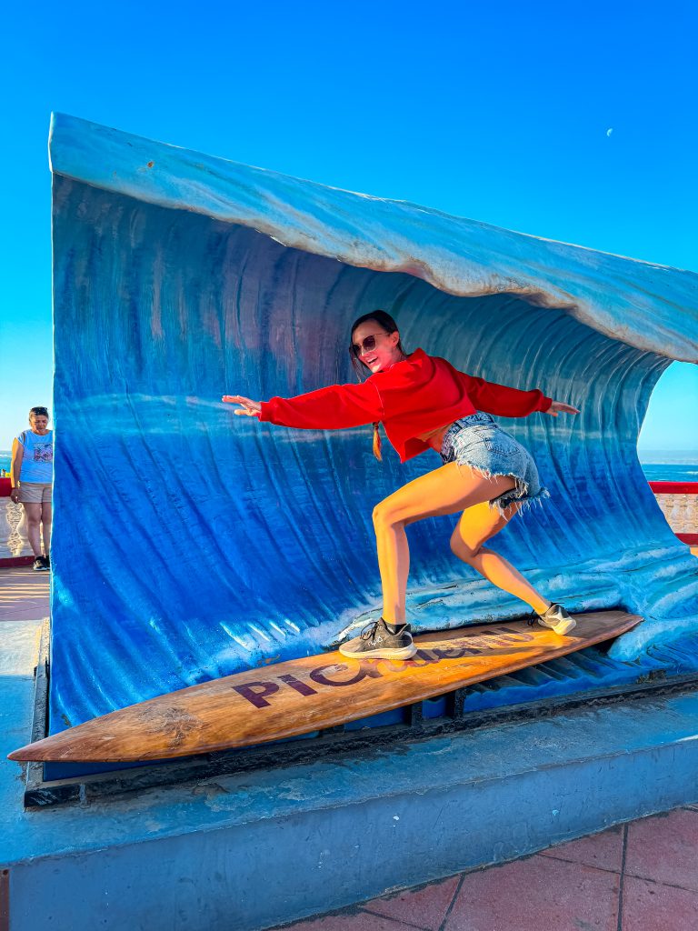 Woman posing on a surf board and wave prop in Pichilemu Chile