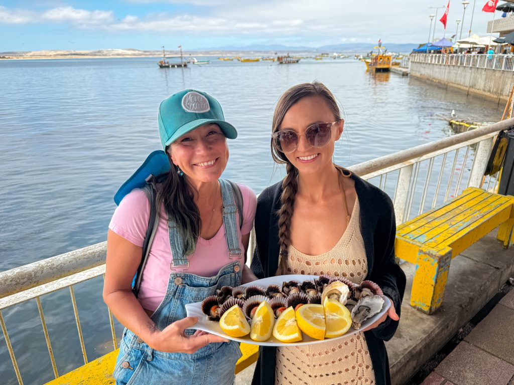 2 women holding a plate of fresh seafood in Tongoy, Chile