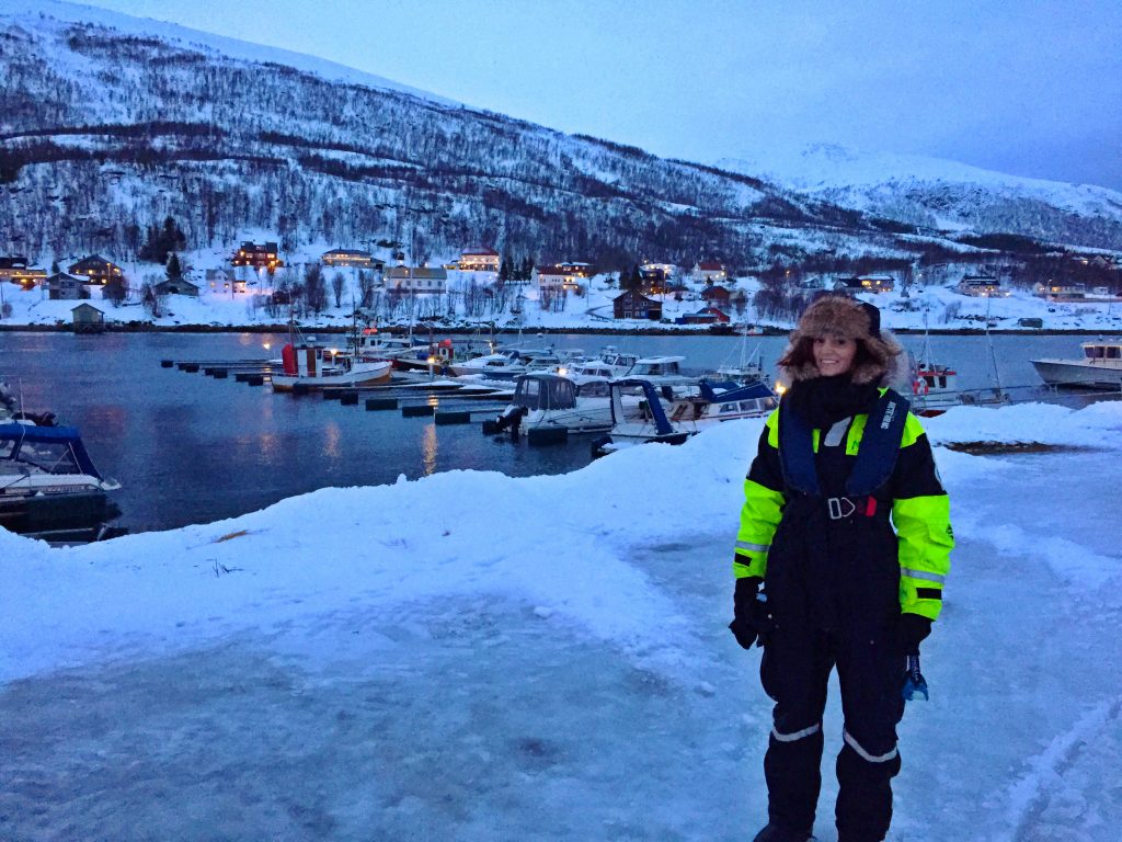 A woman in an arctic suit by the fjord in Tromso, Norway