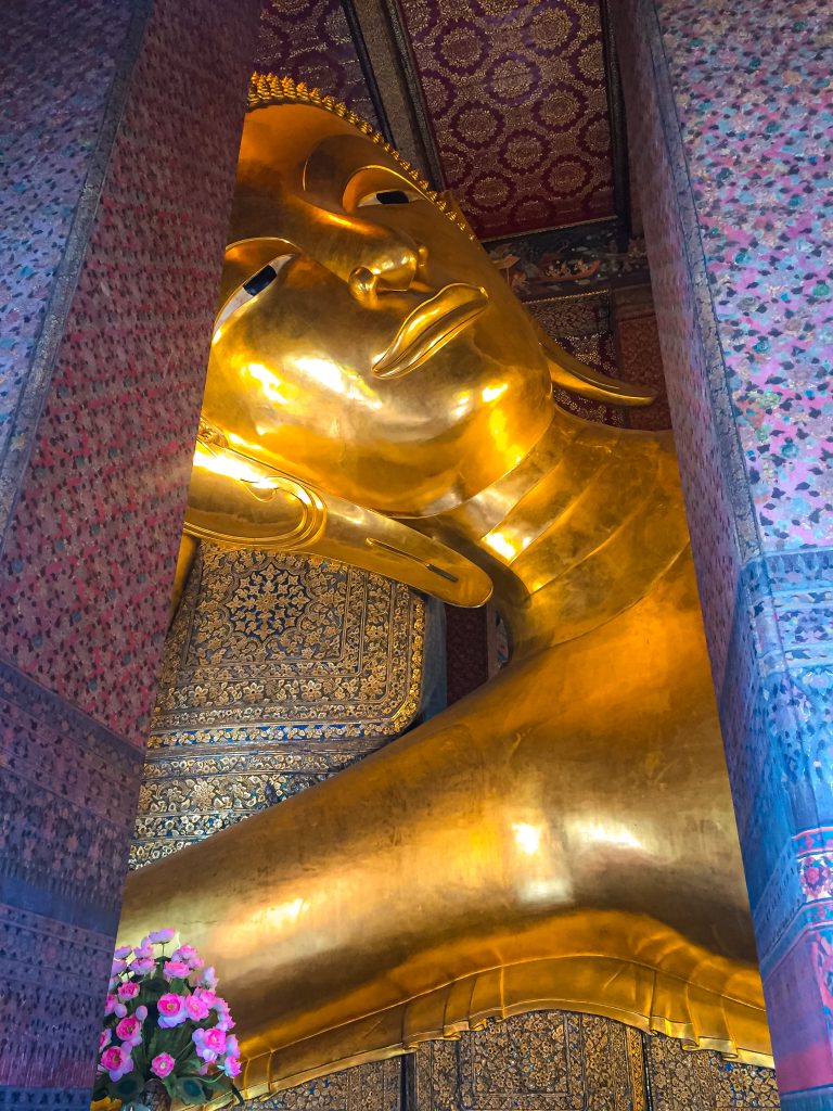 Face of the giant reclining Buddha statue between 2 pillars in Bangkok