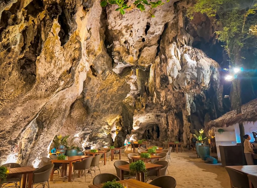 Restaurant tables below towering limestone cave walls