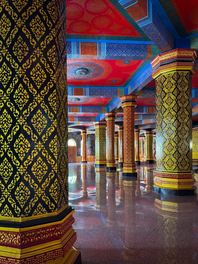 Rows of colorful patterned columns inside Tiger Cave Temple