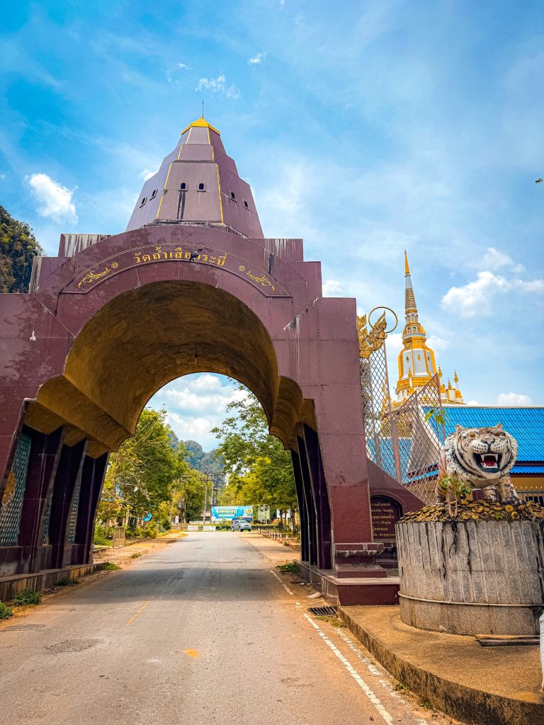 Entrance arch and tiger statue at Tiger Cave Temple in Krabi, Thailand