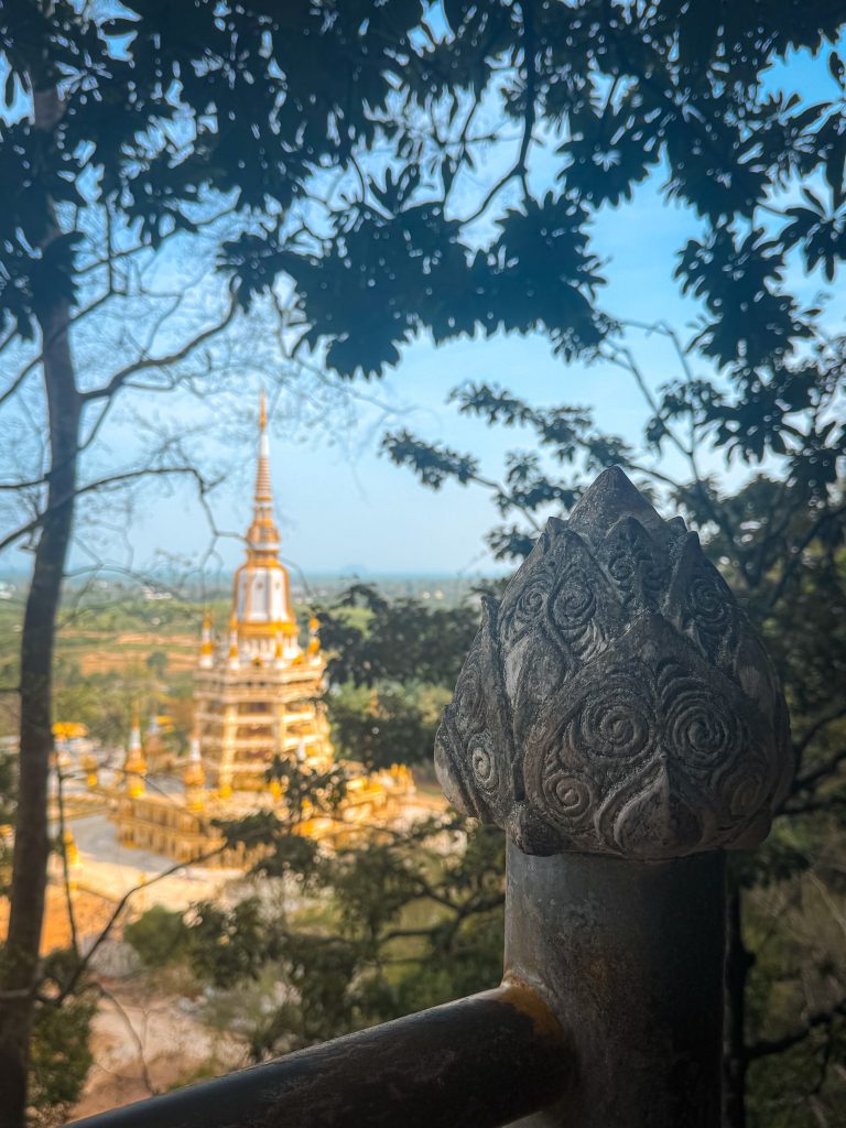 Tiger Cave Temple pagoda seen through the trees from the staircase