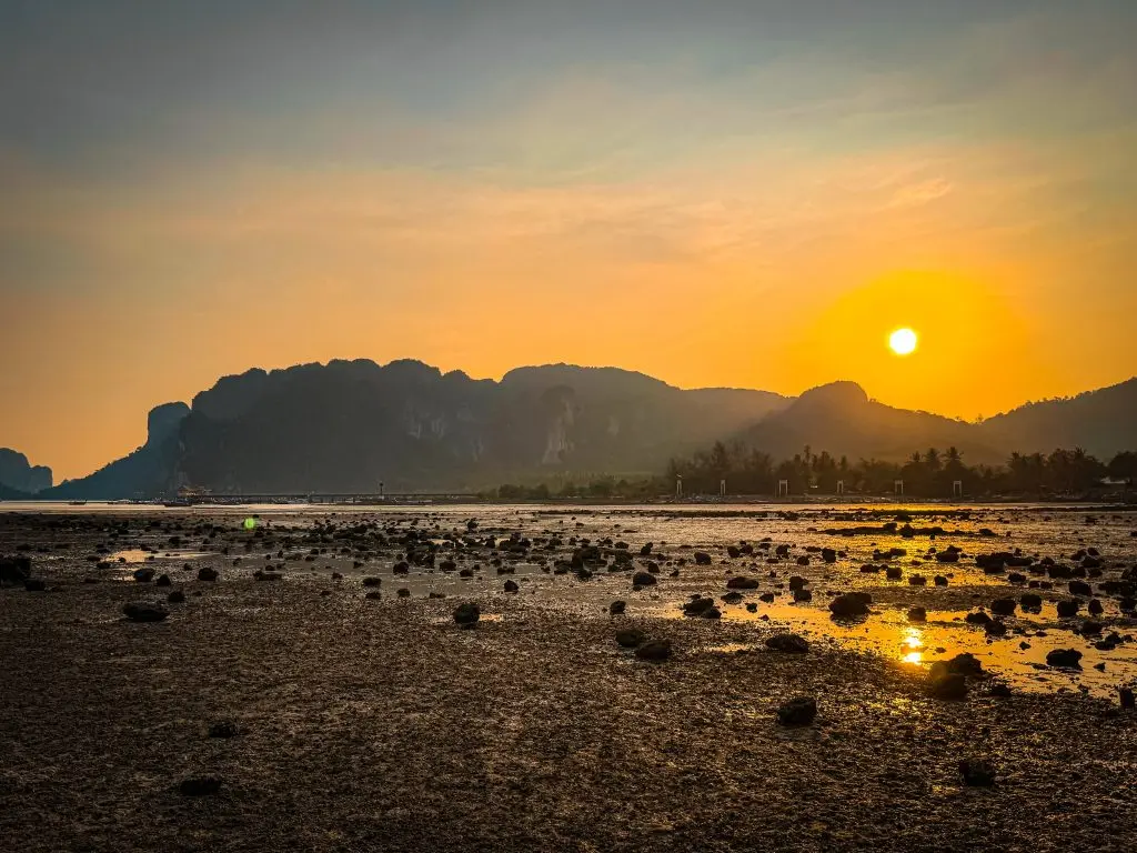 Wide sunset view over limestone cliffs, exposed rocks, and shallow water near Villa Cha-Cha Krabi.