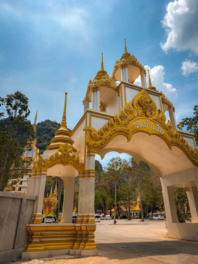 Ornate white and gold gateway at Wat Tham Suea in Krabi