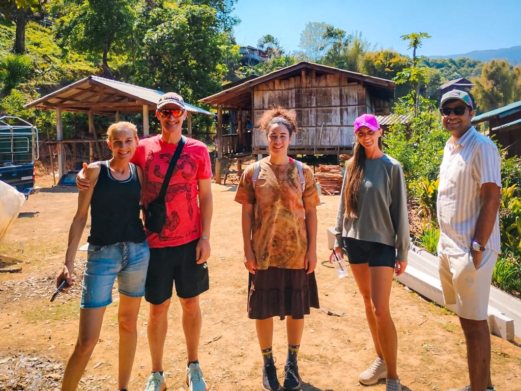 Tour group visiting a traditional mountain village during a Doi Inthanon National Park day trip.