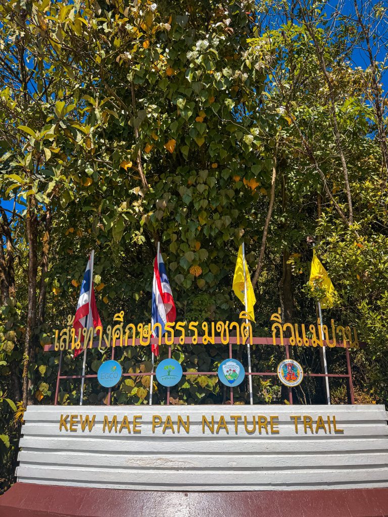 Kew Mae Pan Nature Trail entrance sign surrounded by forest in Doi Inthanon National Park, Thailand.