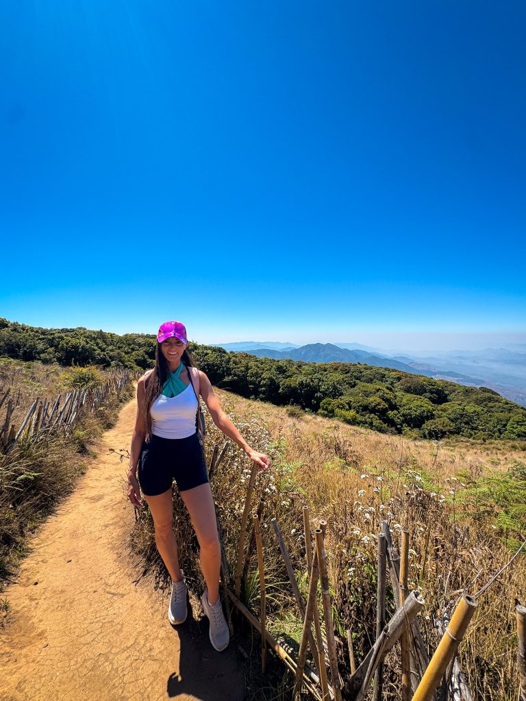 Traveler posing at a dramatic mountain viewpoint while trekking Kew Mae Pan in Doi Inthanon National Park.