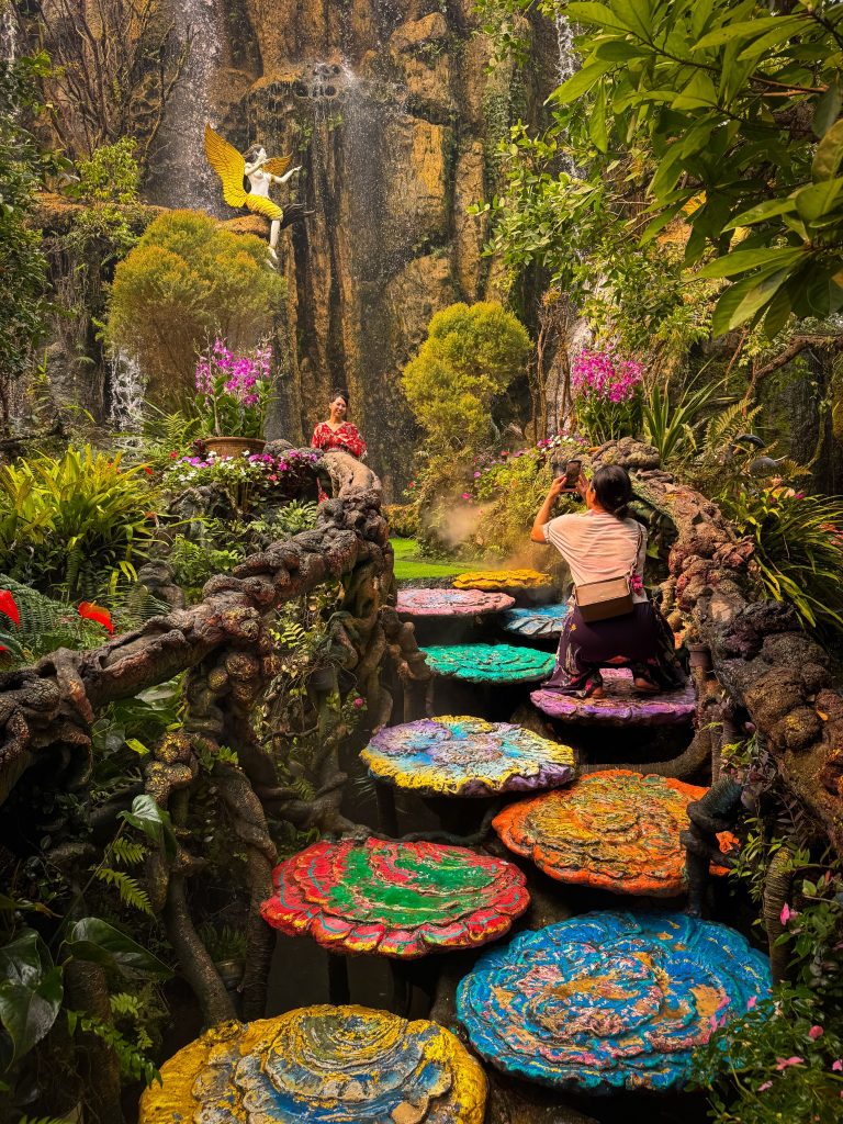 Colorful round stepping stones crossing a garden stream near the waterfall at Lalitta Cafe Chiang Rai.