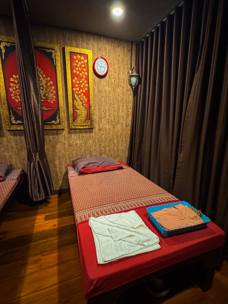 Private massage room with traditional Thai decor and a massage bed at Lalitta Cafe Chiang Rai.