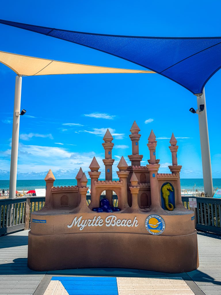 Sandcastle statue on the Myrtle Beach Boardwalk in front of the beach and ocean