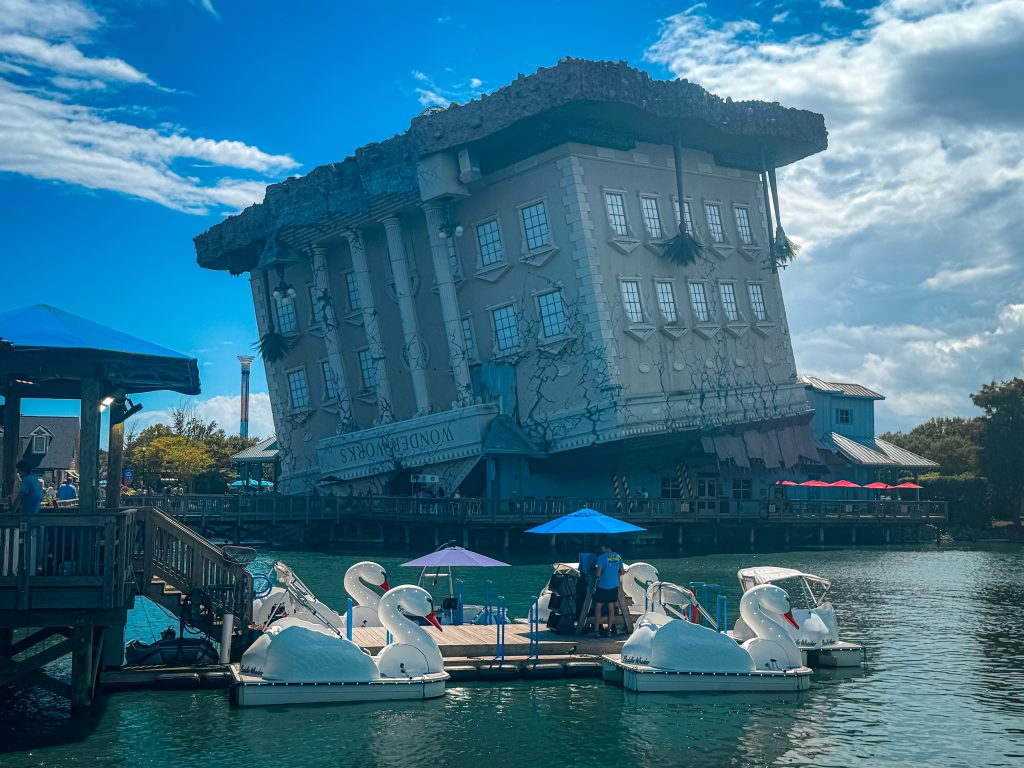WonderWorks upside down house behind the lake and swan paddle boats