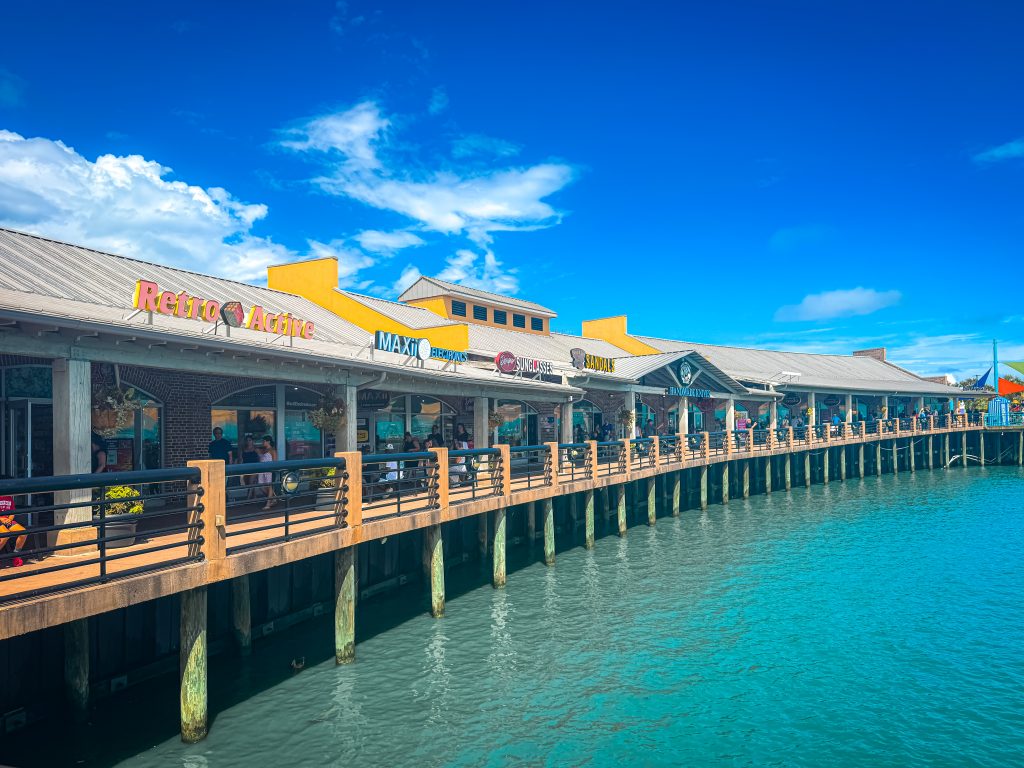 Row of shops on a boardwalk above a blue lake in Myrtle Beach
