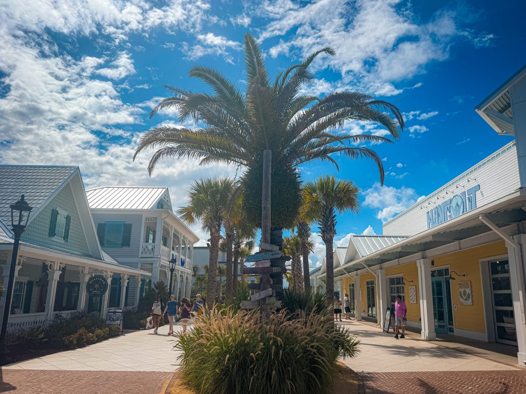 Sidewalks with rows of palm trees in the middle of charming southern buildings at Broadway At The Beach
