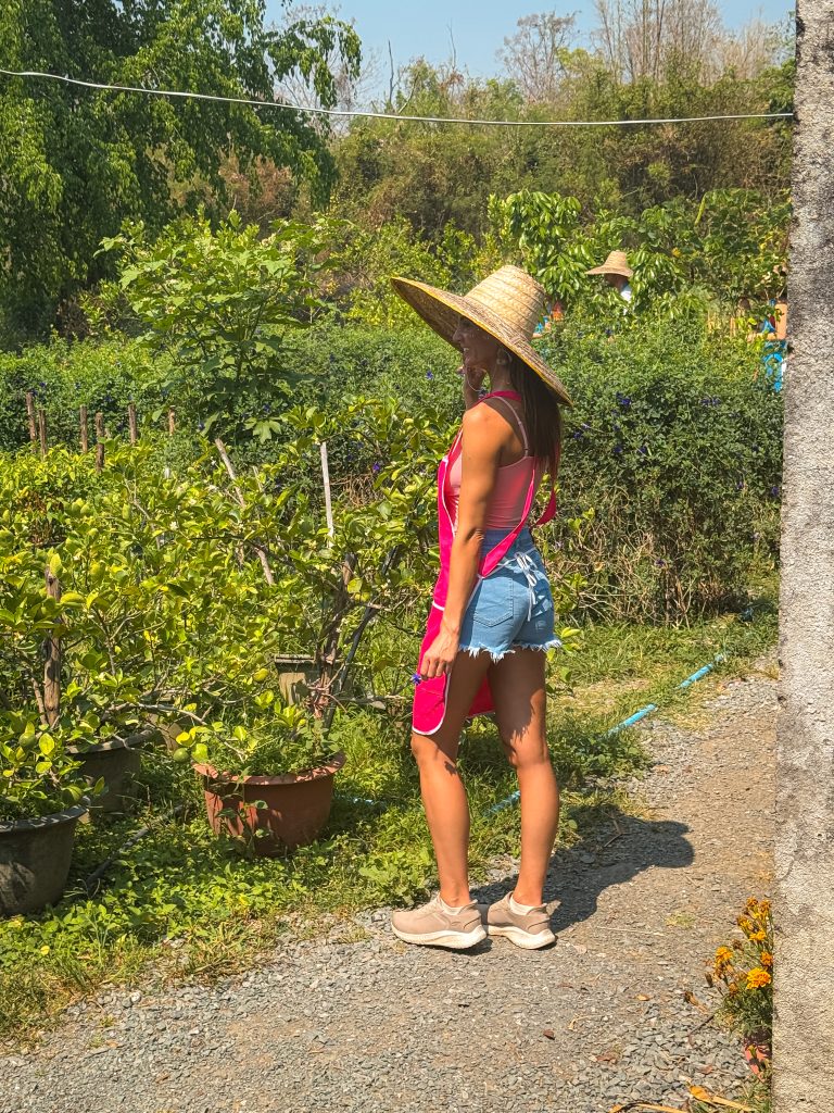 Woman with a giant wide brim hat in a Thai organic garden