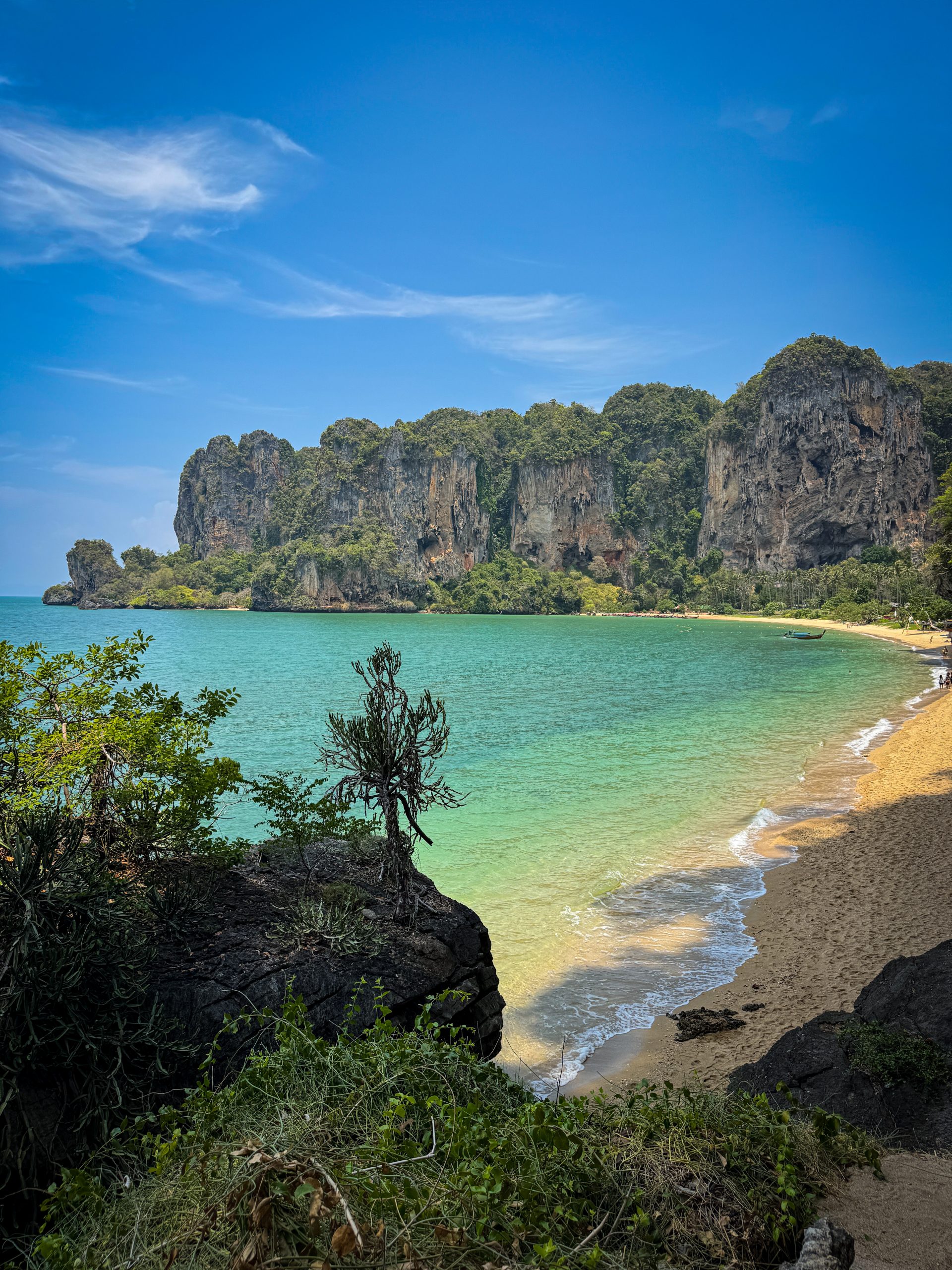 Circular bay with beach, turquoise water, and limestone cliffs lining it
