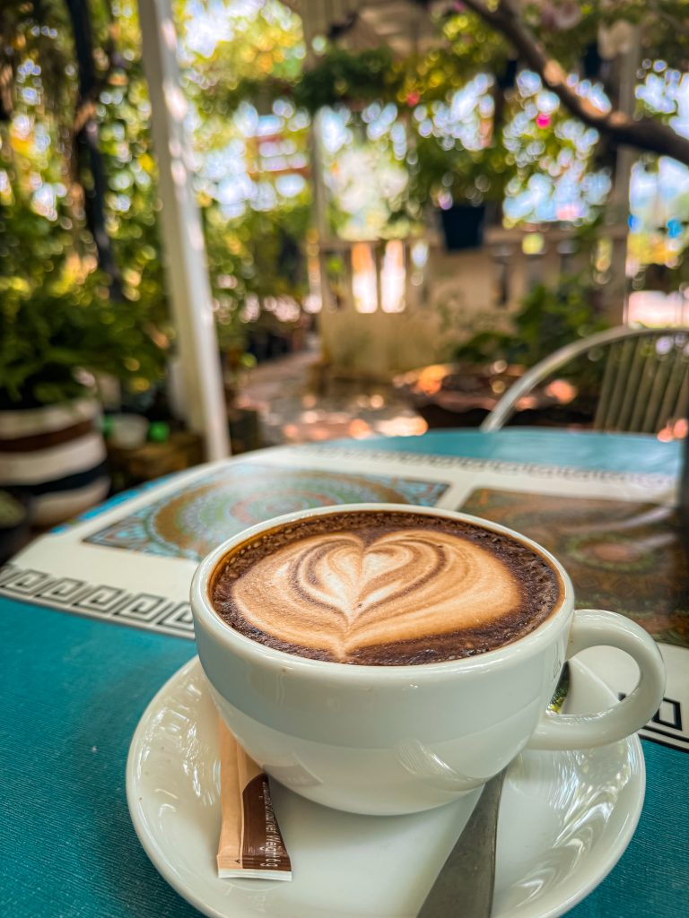 Mocha latte in a mug with heart design on the foam in an outdoor garden cafe in Thailand