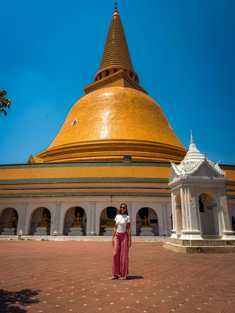 A woman standing in front of Thai temple Phra Pathom hedi