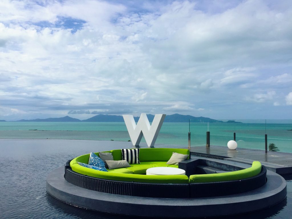 Green circular lounge seating with view of turquoise water below