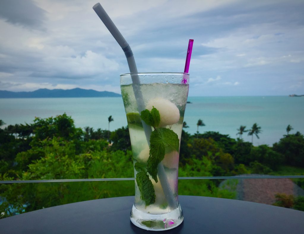 Lychee mojito with view of turquoise water below