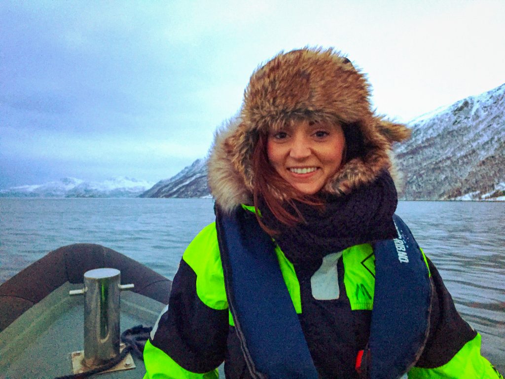 Woman wearing a fur covered hat and arctic suit on a rib boat in Tromso, Norway