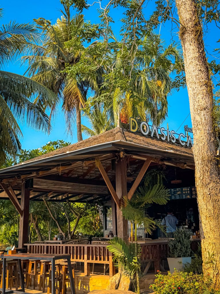 Exterior of D’oasis Cafe surrounded by tropical trees near Ao Nam Mao Pier in Krabi.