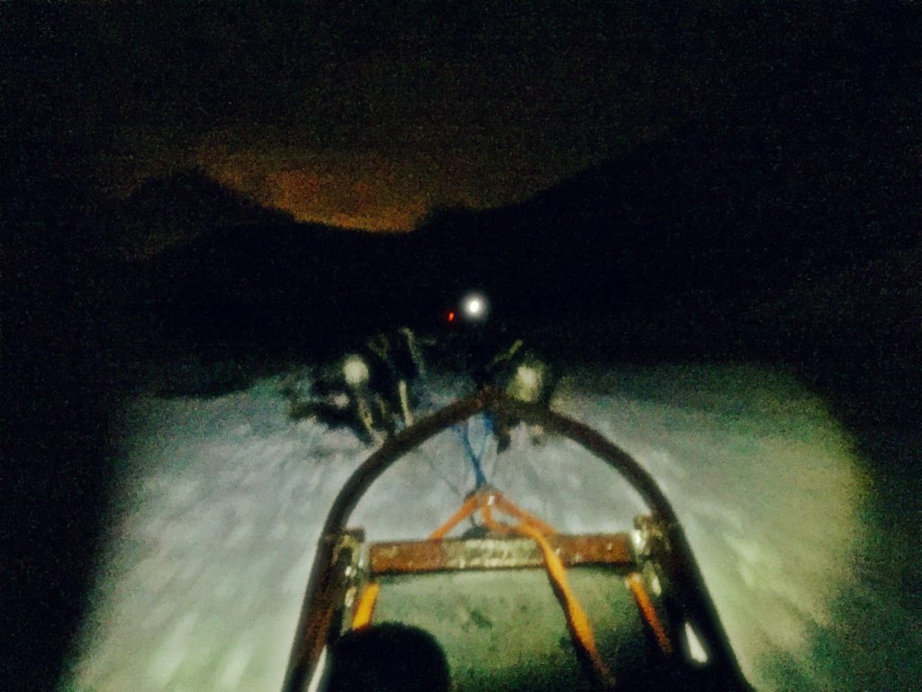 Front of the dog sled being pulled at night