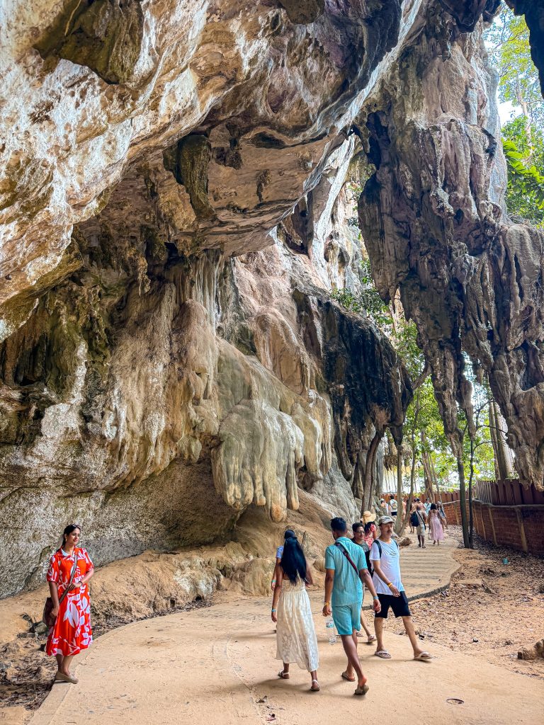 Dramatic hanging limestone formations above the walking path toward Phra Nang Beach