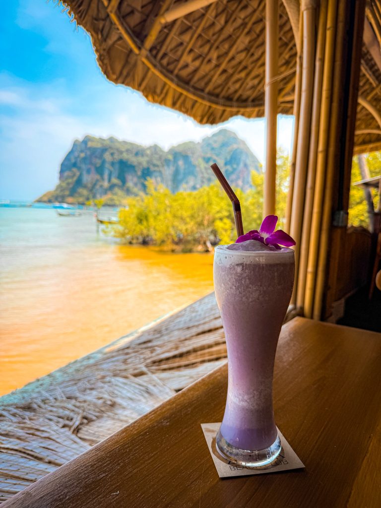 Purple smoothie decorated with an orchid overlooking mangroves and limestone cliffs from Zoluna.