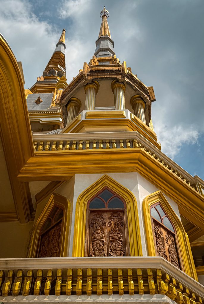 Low-angle view of the gold and white pagoda architecture at Tiger Cave Temple