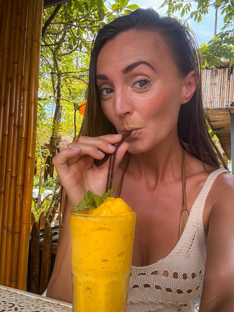 Traveler drinking a fresh mango smoothie at Villa Cha-Cha Krabi Beachfront Resort.
