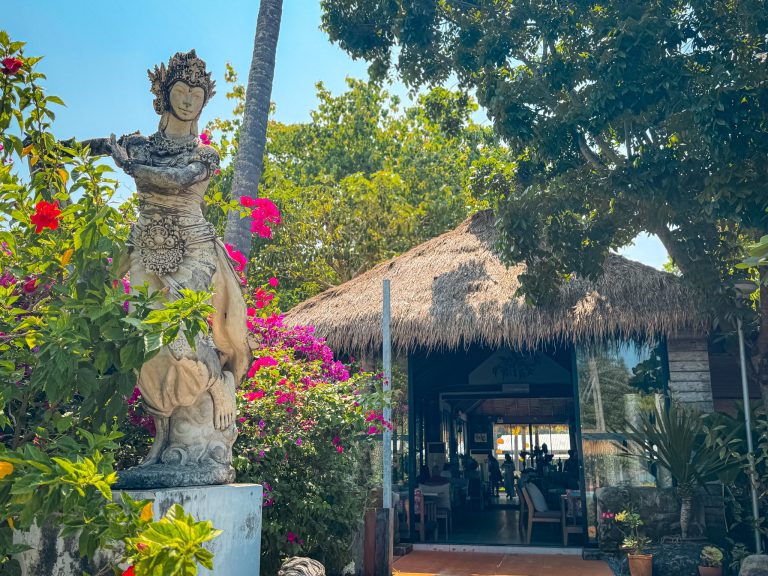 Thai statue and bougainvillea beside the open-air restaurant entrance at Villa Cha-Cha Krabi.
