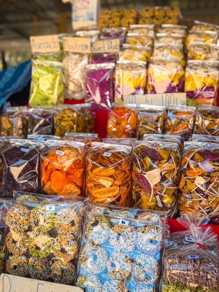 Colorful bags of dried fruit, vegetable chips, and local snacks for sale at a Hmong market during a Doi Inthanon tour.