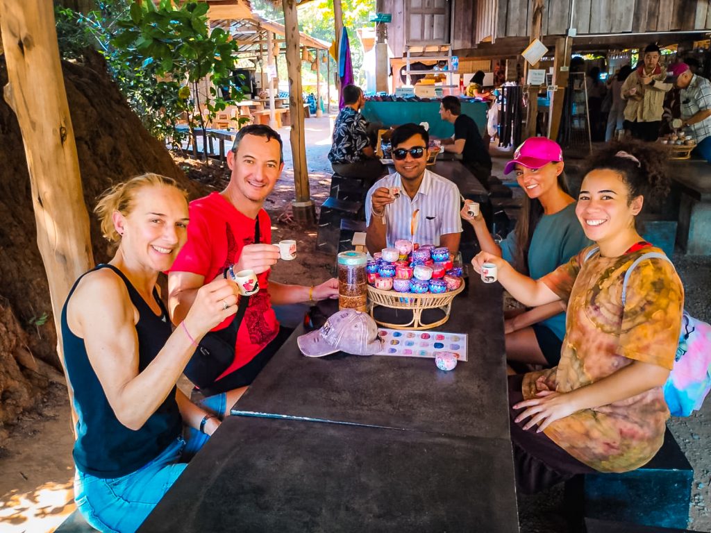 Travelers tasting locally grown coffee during a Hmong village stop on a Doi Inthanon tour from Chiang Mai.