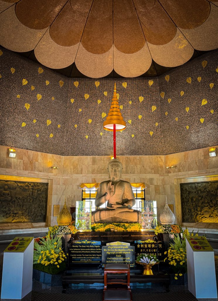Seated Buddha statue surrounded by golden details inside one of the Royal Twin Pagodas at Doi Inthanon National Park.
