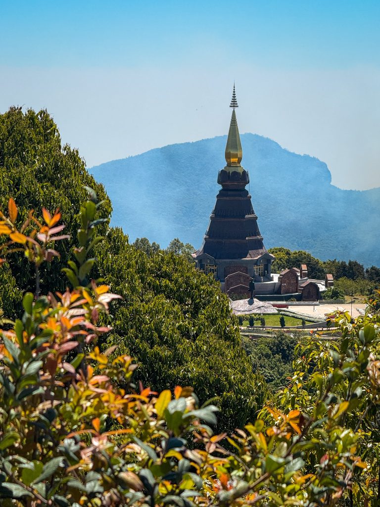 Royal Pagoda rising above lush forest with a mountain backdrop in Doi Inthanon National Park near Chiang Mai.