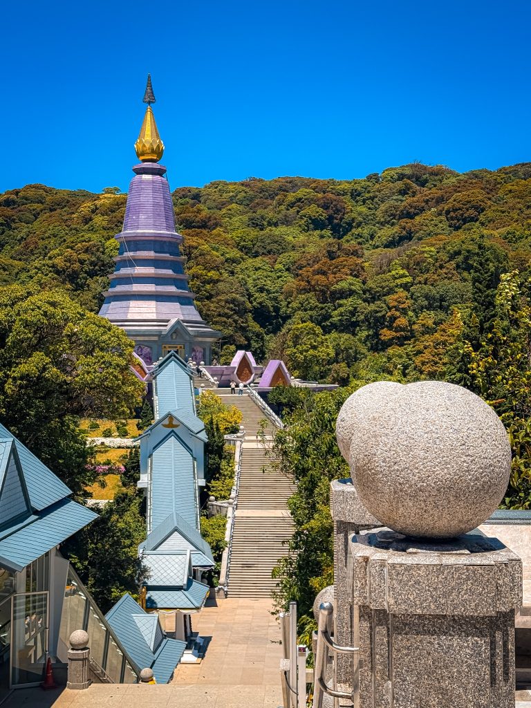 Elevated view overlooking one of the Royal Twin Pagodas, gardens, and surrounding forest in Doi Inthanon National Park.