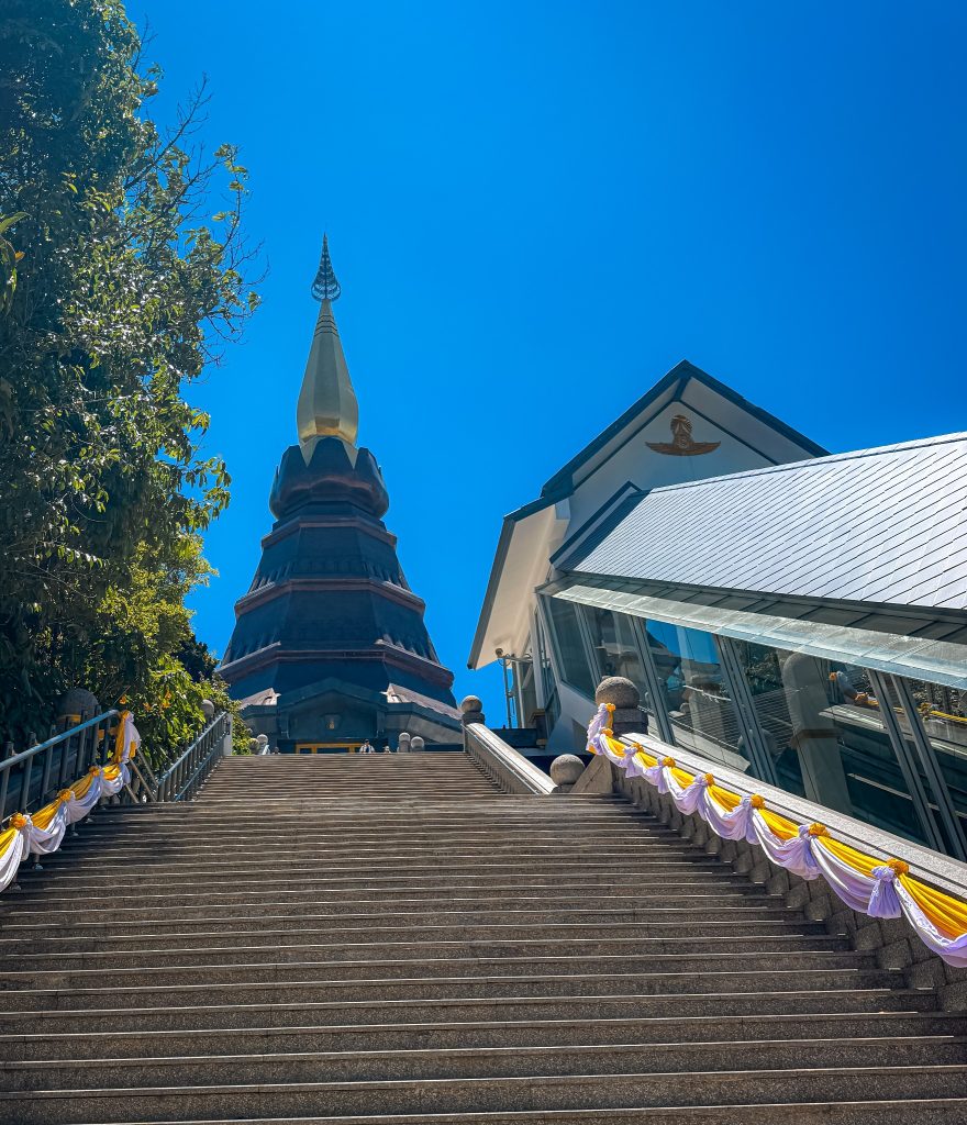 Long staircase leading up to a Royal Pagoda beneath a bright blue sky at Doi Inthanon National Park.